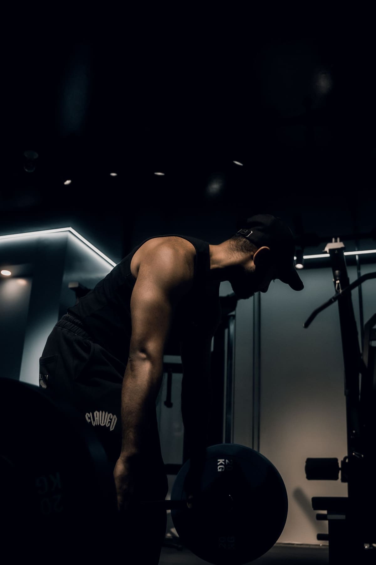 Silhouette of an athlete deadlifting in a dimly lit gym