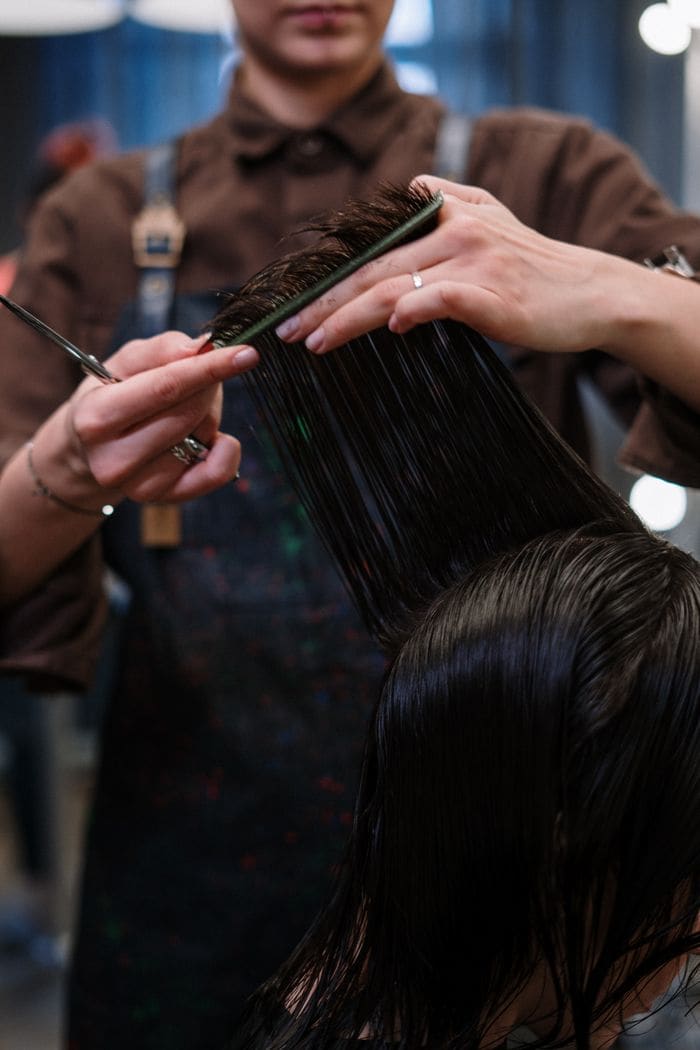 A stylist combing and preparing hair for a precision cut