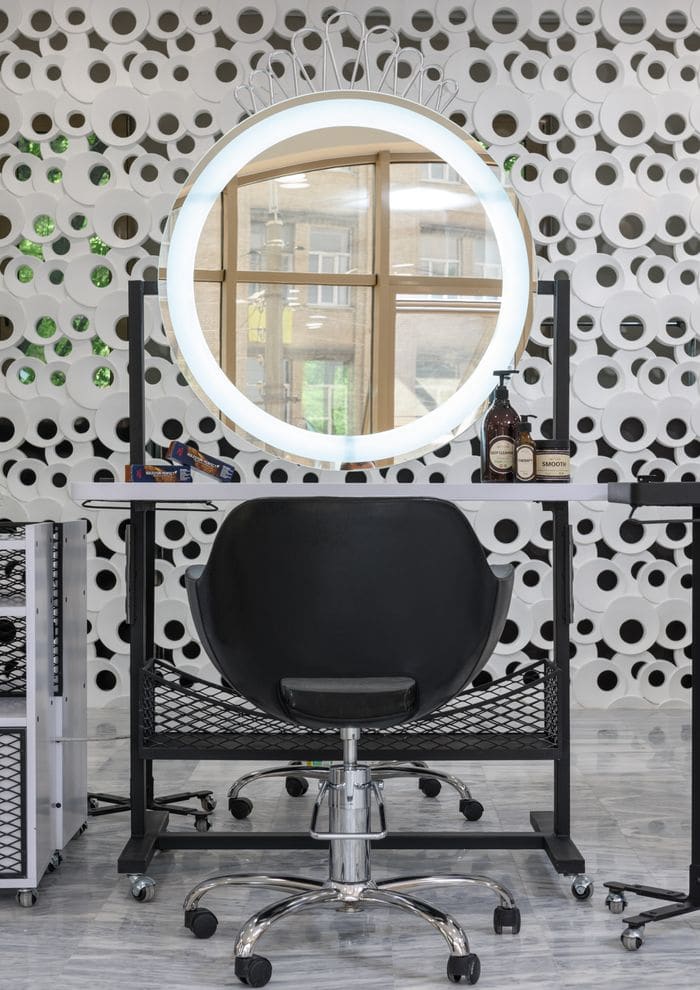 A salon styling station with a lit mirror